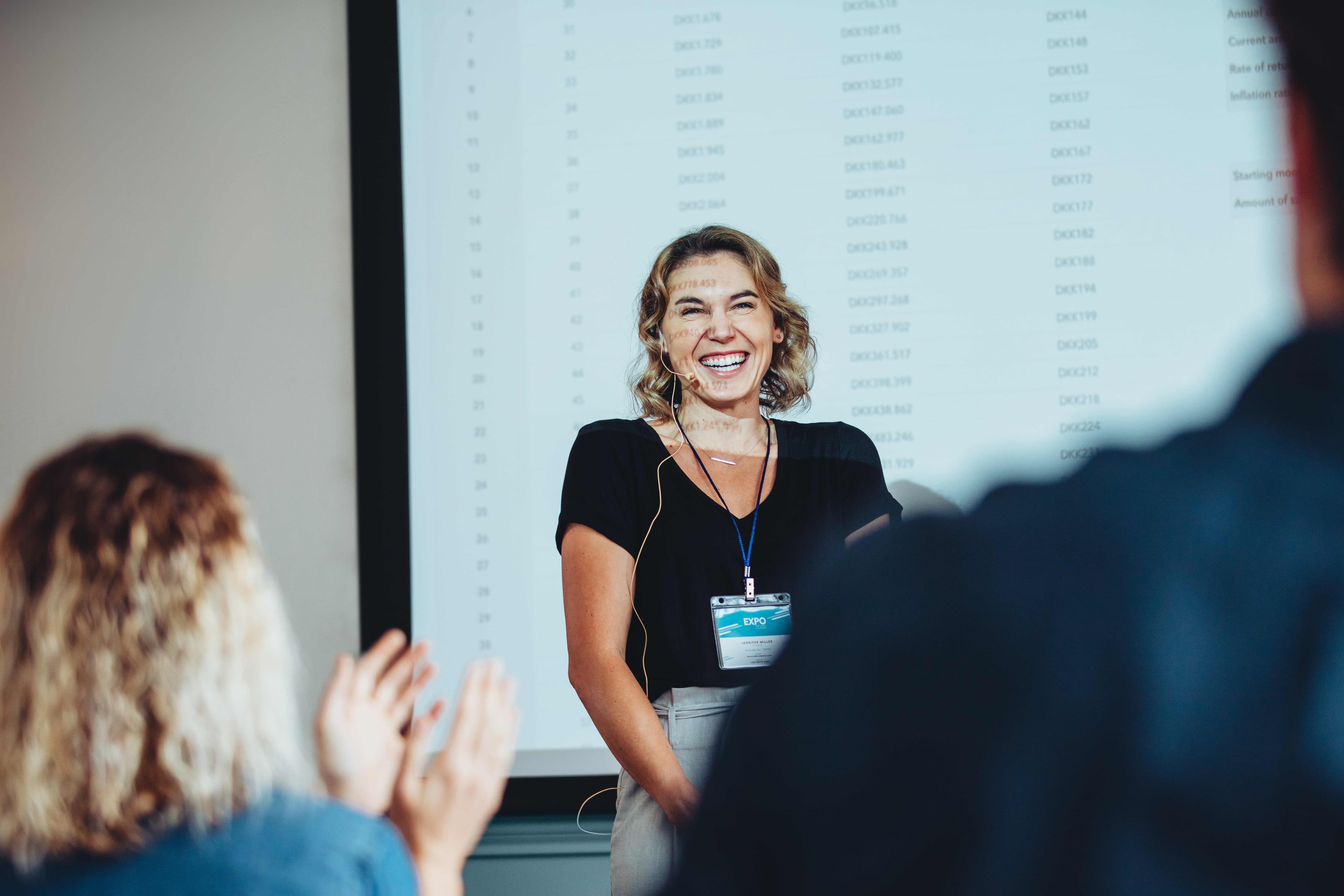 Confident speaker receiving applause during a professional presentation